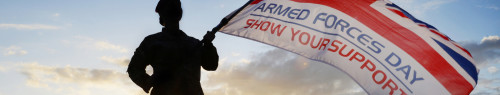 A soldier of 16 Medical Regiment waving the Armed Forces Day - Show your Support flag.