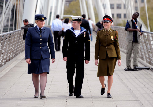 From left, a Royal Air Force servicewoman, a Royal Navy sailor and an Army soldier stroll through London prior to Armed Forces Day.
