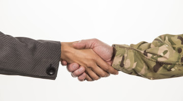Close up of handshake between businesswoman and soldier wearing camouflage