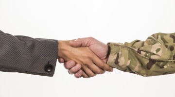 Close up of handshake between businesswoman and soldier wearing camouflage
