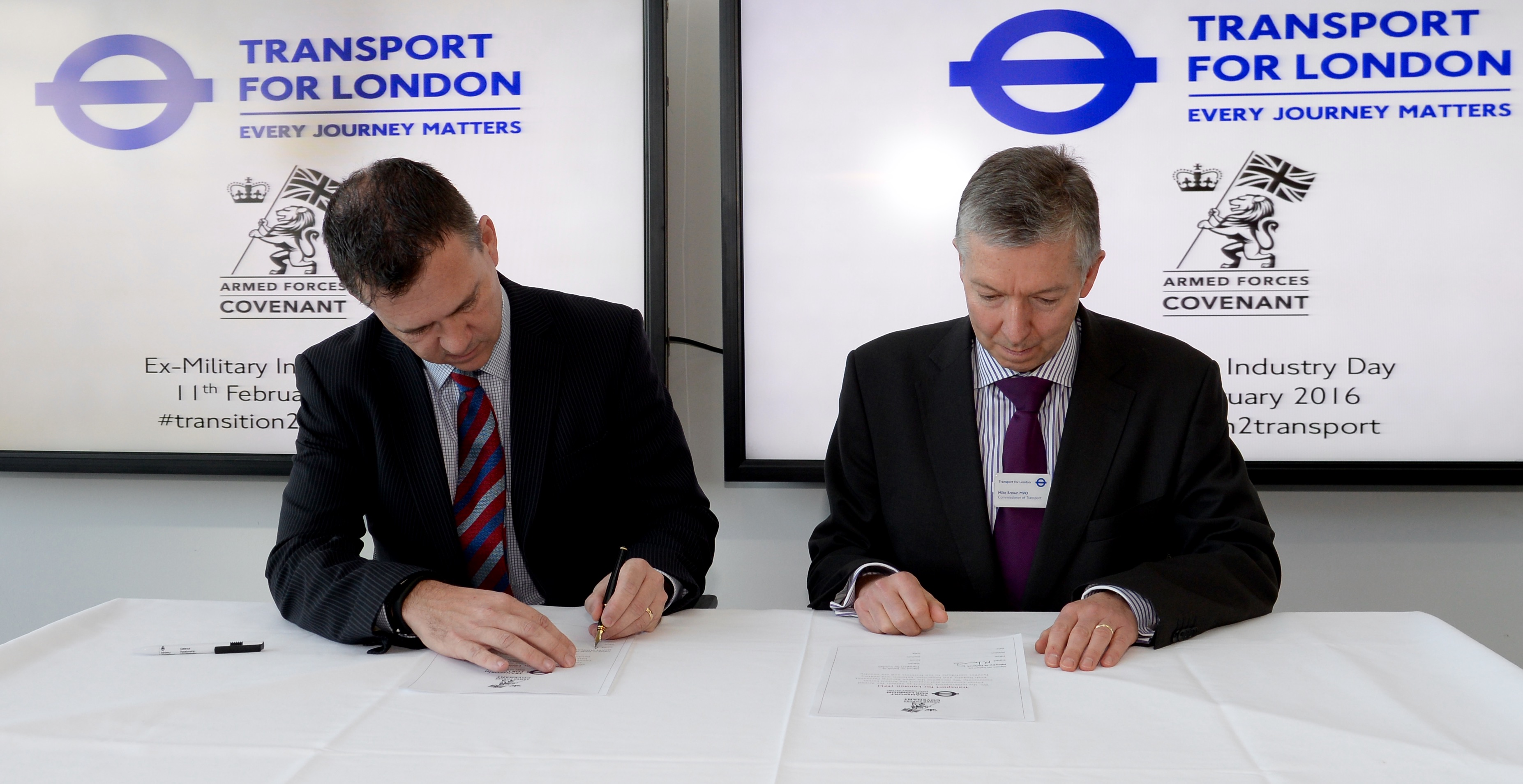 Mark Lancaster MP, and Mike Brown, Transport Commissioner, sign the Armed Forces Covenant.