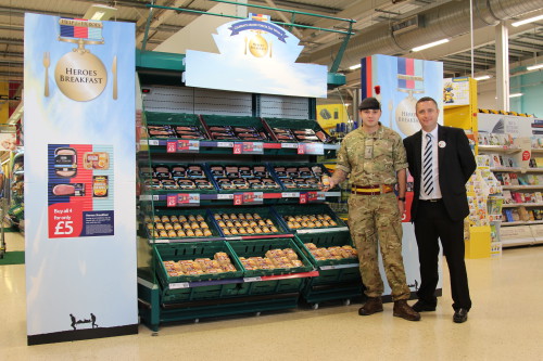 Armed forces representative and Tesco member of staff in front of a Help for Heroes breakfast display in a Tesco store.