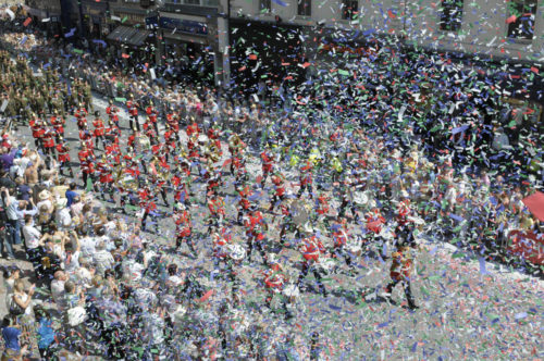 Crowds cheer as soldiers march through a ticker tape parade in Cardiff for the Armed Forces Day 2010 National Event.