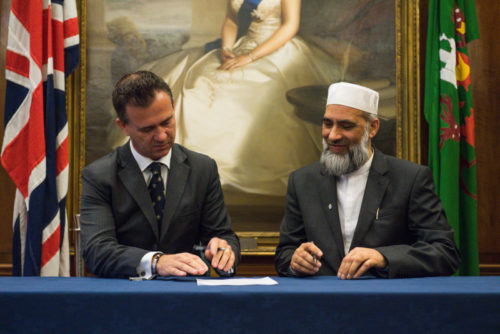 Mark Lancaster, Minister for Defence Veterans, Reserves and Personnel counter signs the Armed Forces Covenant with Dr Musharraf Hussain Chief Imam.